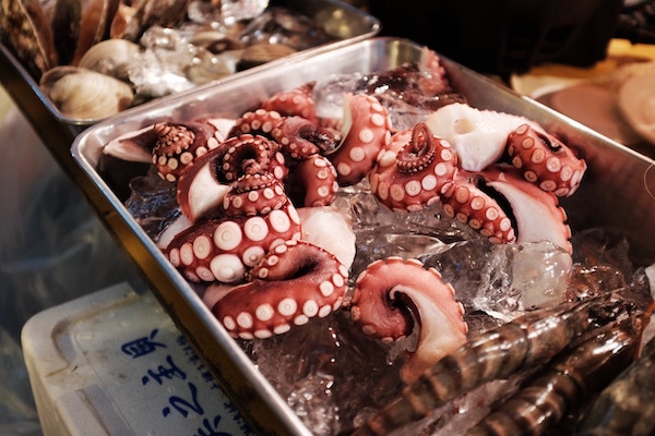 pink/red octopus tentacles chilling on ice before being cooked